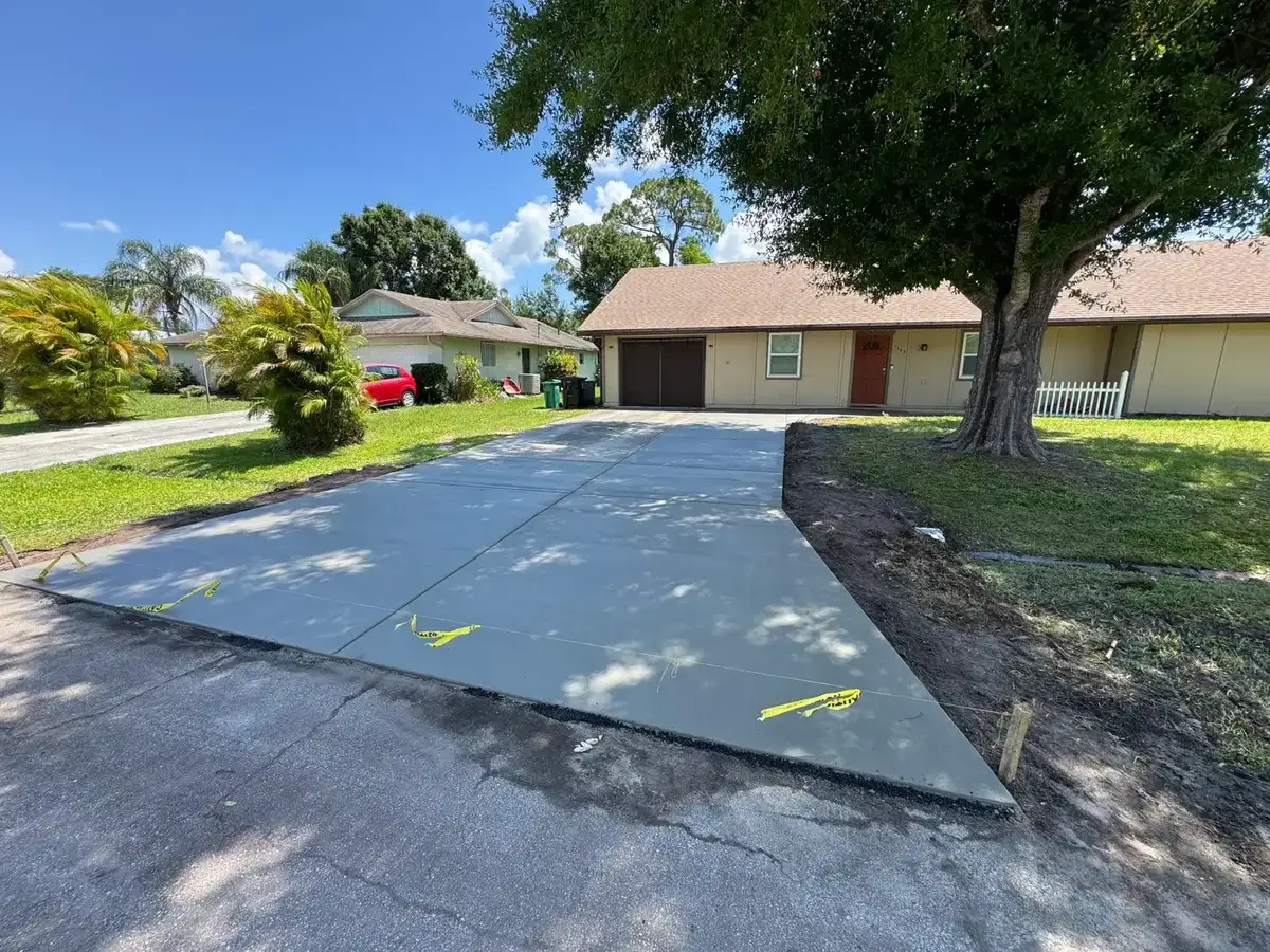 Freshly poured concrete driveway in front of a single-story home