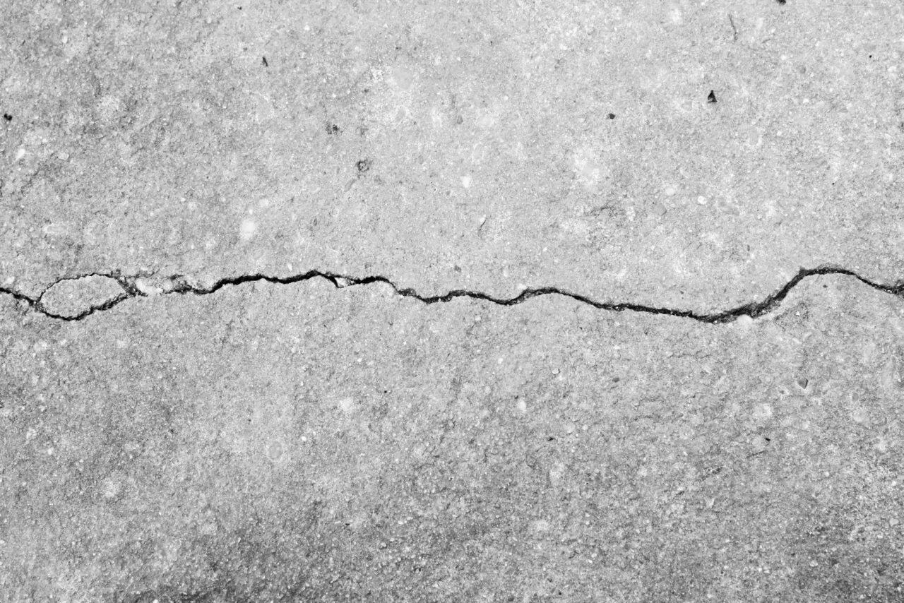A single crack running across the surface of a gray concrete slab